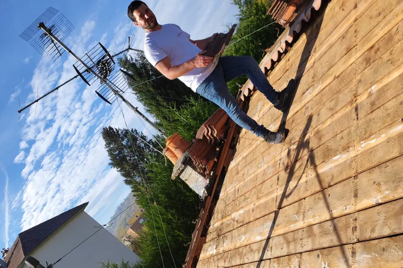 Couvreur travaillant sur une charpente mise à nu lors d'une réfection